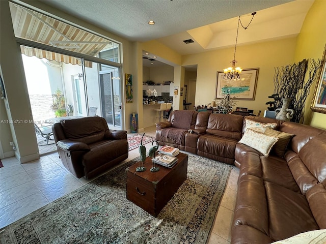 living room featuring tile patterned flooring, a textured ceiling, and a notable chandelier