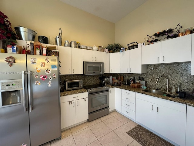 kitchen featuring white cabinets, dark stone countertops, sink, and stainless steel appliances