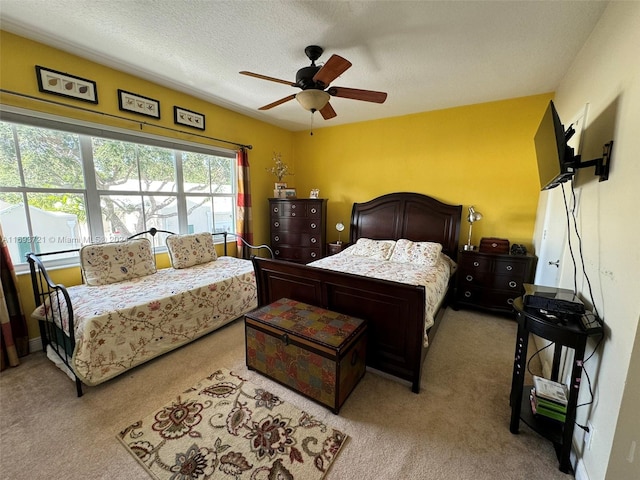 carpeted bedroom with ceiling fan and a textured ceiling