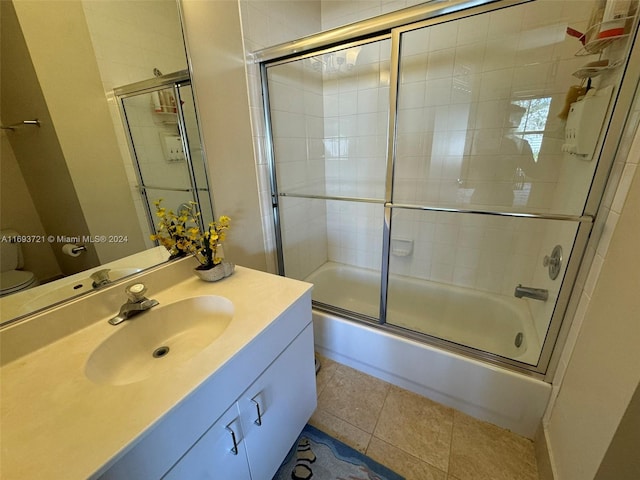 full bathroom with tile patterned flooring, vanity, toilet, and combined bath / shower with glass door