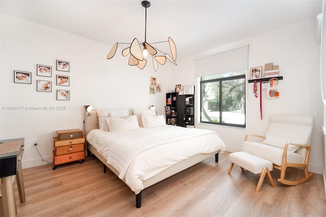 bedroom with a chandelier and hardwood / wood-style floors