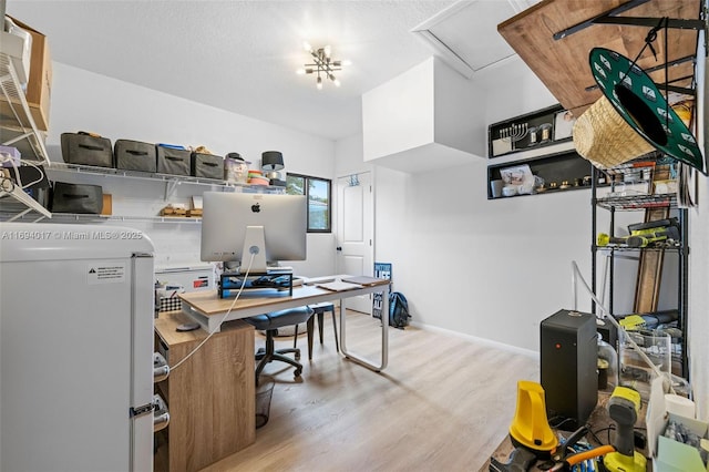 office area with a textured ceiling and light wood-type flooring