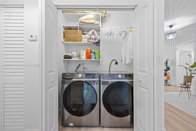 laundry area featuring hardwood / wood-style flooring and washing machine and dryer