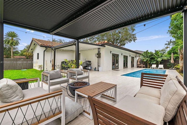 view of patio featuring a fenced in pool and an outdoor living space with a fire pit