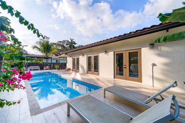 view of swimming pool with a patio and french doors