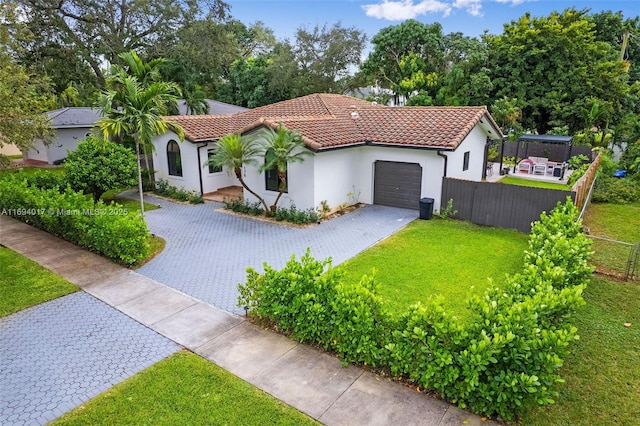 mediterranean / spanish-style house with a garage and a front yard