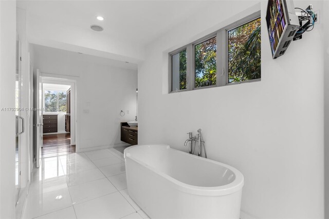 bathroom with tile patterned flooring, a bathtub, and vanity