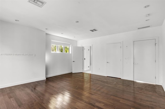 unfurnished room with dark wood-type flooring