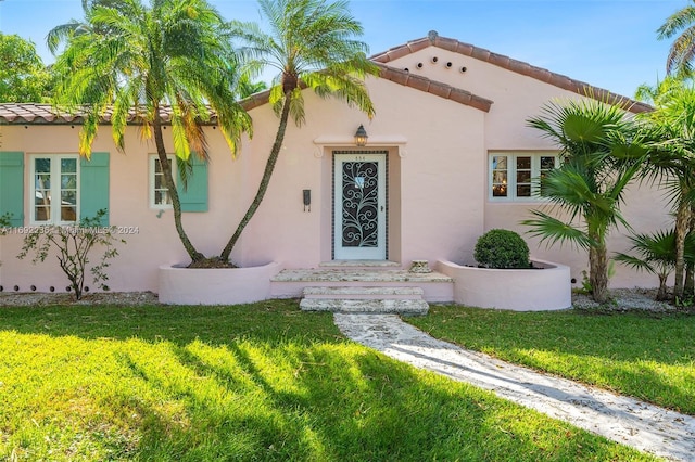 view of exterior entry with a yard