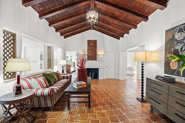 living room featuring beamed ceiling, high vaulted ceiling, wooden ceiling, and an inviting chandelier