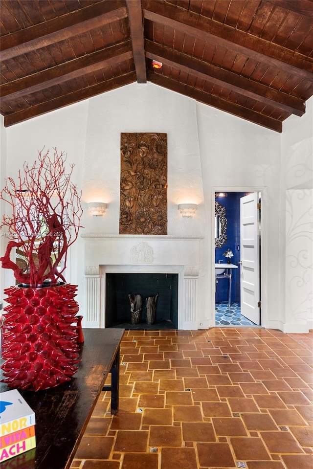 unfurnished living room with vaulted ceiling with beams, a fireplace, and wood ceiling