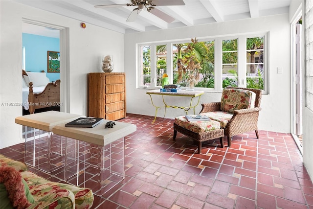 sunroom with ceiling fan and beam ceiling