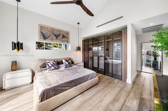 bedroom featuring access to outside, wood finished floors, visible vents, and high vaulted ceiling