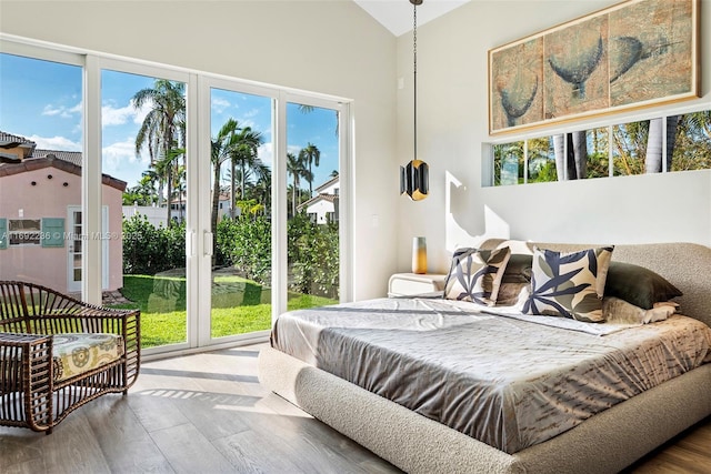 bedroom featuring vaulted ceiling, access to outside, and wood finished floors