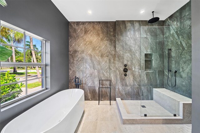 bathroom featuring separate shower and tub and tile walls