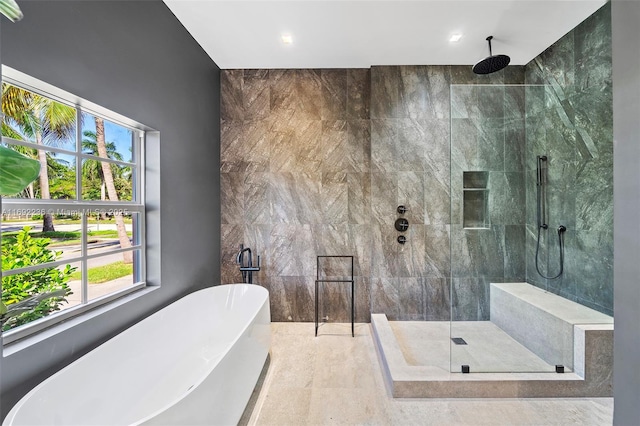 full bath with a tile shower and a freestanding bath