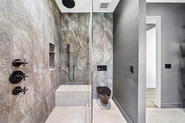 full bath featuring visible vents, baseboards, and a tile shower