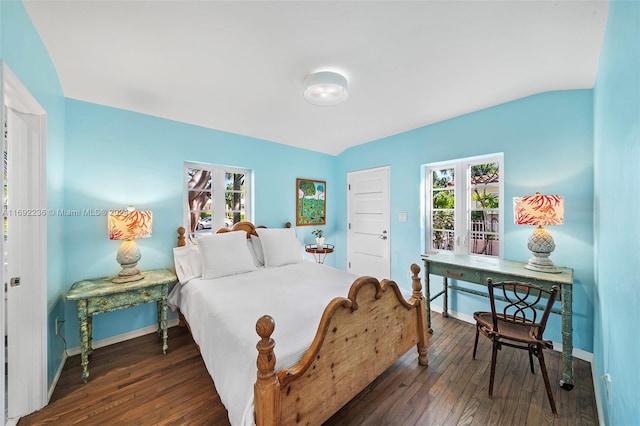 bedroom with lofted ceiling, multiple windows, and dark wood-type flooring