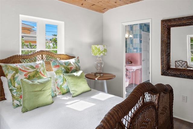 bedroom featuring ensuite bathroom, dark hardwood / wood-style flooring, and wooden ceiling