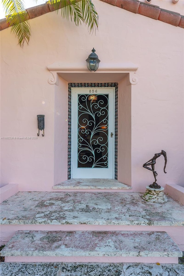 view of exterior entry featuring stucco siding