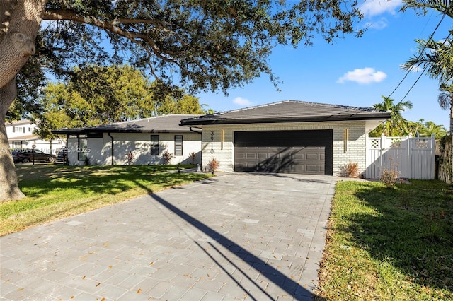 single story home featuring a garage and a front yard