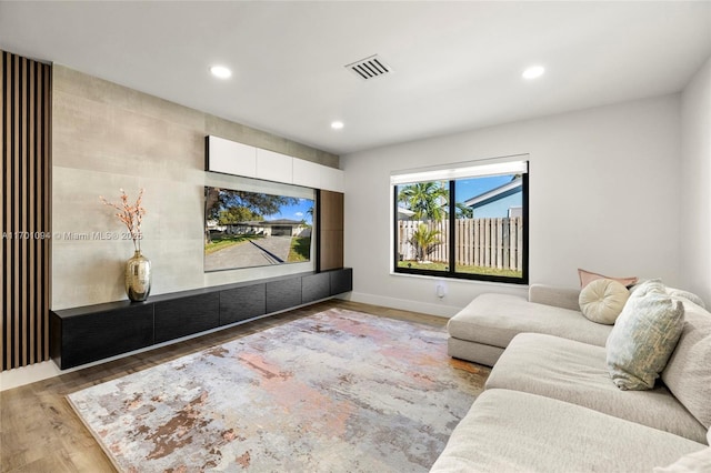 cinema room featuring baseboards, visible vents, wood finished floors, and recessed lighting