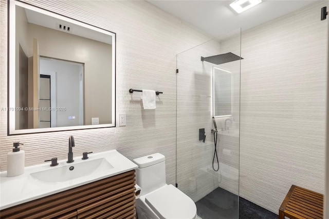 bathroom featuring toilet, backsplash, vanity, a walk in shower, and tile walls