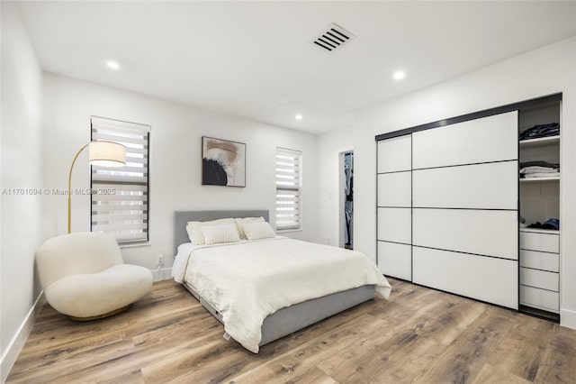 bedroom featuring baseboards, visible vents, wood finished floors, and recessed lighting