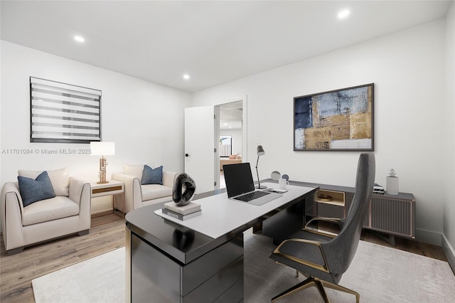 home office with baseboards, light wood-style flooring, and recessed lighting