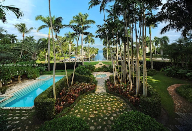 view of property's community featuring a lawn and a swimming pool