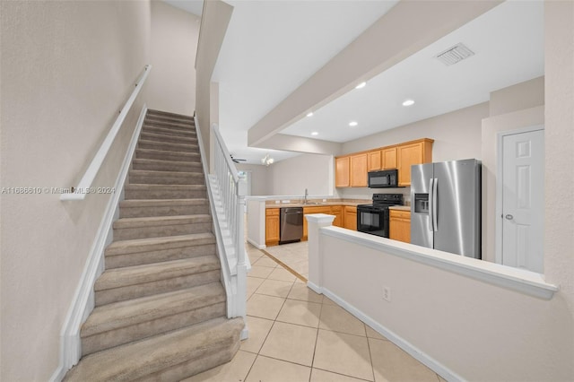 kitchen featuring sink, kitchen peninsula, light brown cabinetry, light tile patterned floors, and black appliances