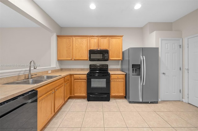 kitchen with light tile patterned floors, sink, and black appliances