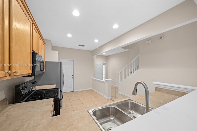 kitchen featuring light tile patterned floors, sink, and black appliances