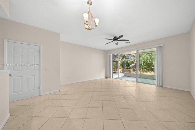 unfurnished room featuring light tile patterned floors and ceiling fan with notable chandelier