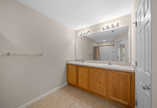 bathroom featuring tile patterned flooring, a textured ceiling, vanity, and walk in shower