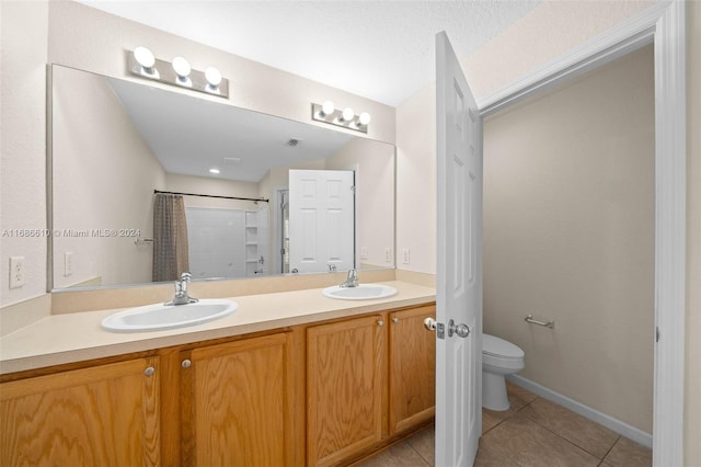 bathroom with tile patterned floors, walk in shower, vanity, and toilet