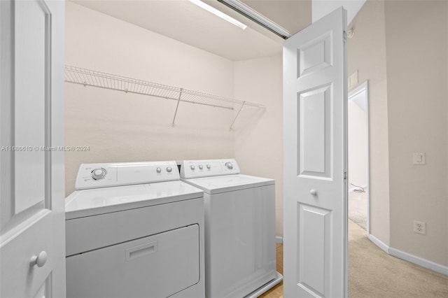 laundry area featuring separate washer and dryer and light colored carpet