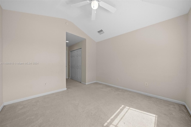 unfurnished room with ceiling fan, light colored carpet, and lofted ceiling