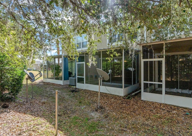 back of property featuring central AC unit and a sunroom