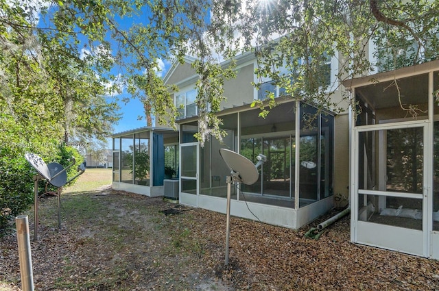 back of property featuring cooling unit and a sunroom