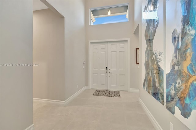 entryway featuring light colored carpet and a high ceiling