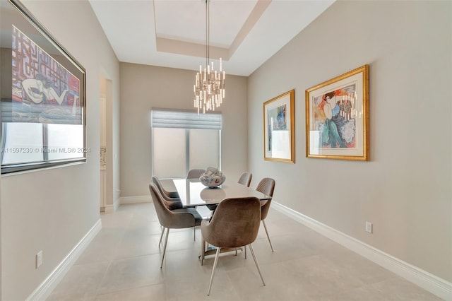 dining area featuring plenty of natural light, a raised ceiling, and a chandelier