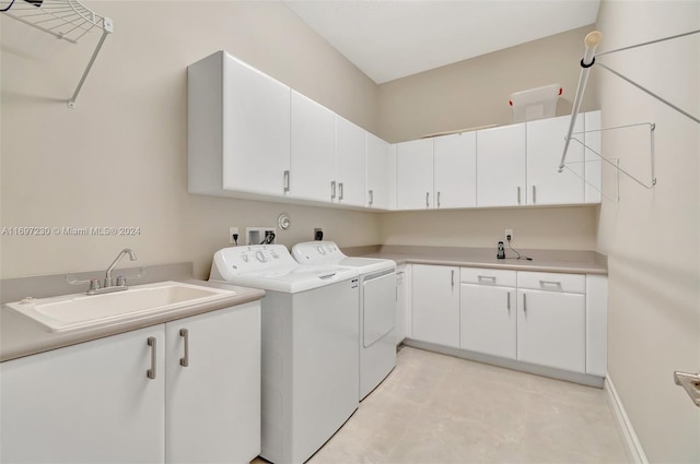 laundry area featuring washer and dryer, sink, light tile patterned floors, and cabinets