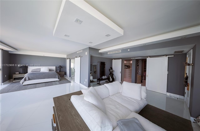 bedroom featuring a barn door and light tile patterned flooring