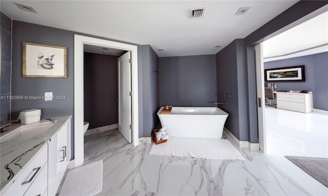 bathroom with a bathing tub, vanity, and toilet