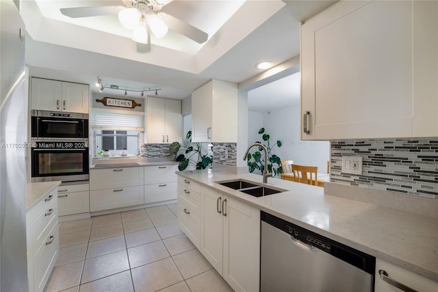 kitchen with white cabinetry, dishwasher, sink, tasteful backsplash, and light tile patterned floors