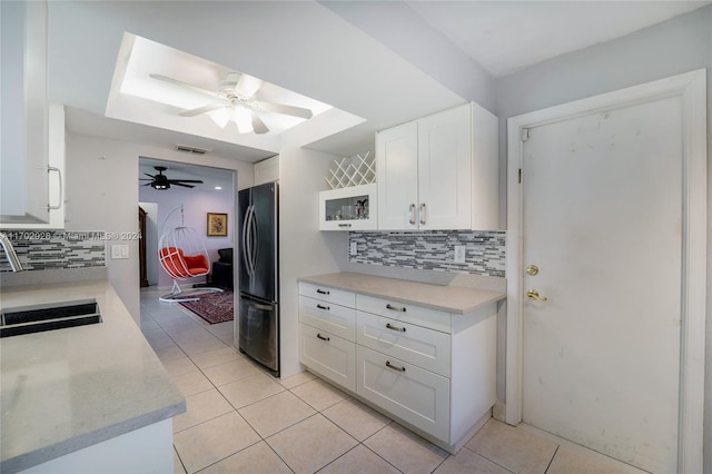 kitchen with white cabinetry, stainless steel refrigerator, tasteful backsplash, and light tile patterned flooring