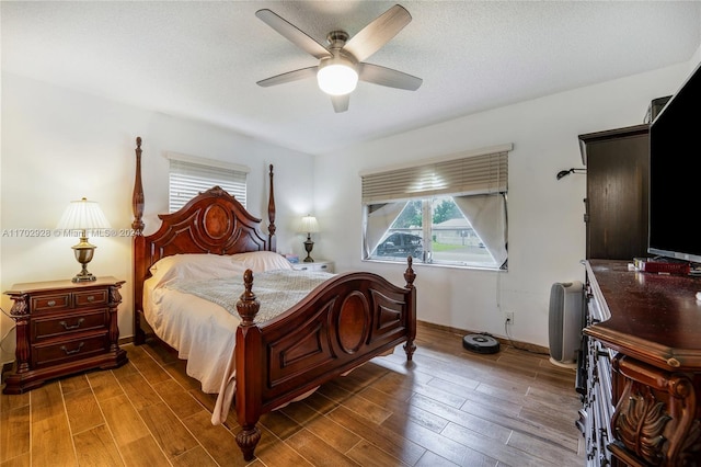 bedroom featuring a textured ceiling, dark hardwood / wood-style floors, and ceiling fan