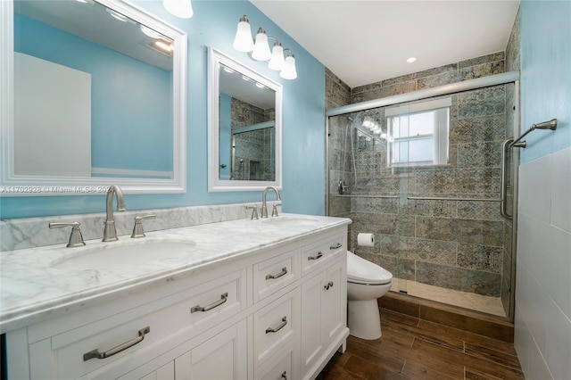 bathroom with wood-type flooring, vanity, toilet, and an enclosed shower