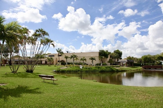 view of property's community featuring a lawn and a water view